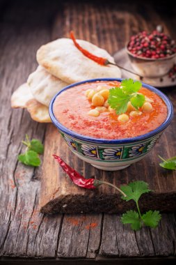 Cream soup puree of roasted tomatoes and peppers served with chickpeas cilantro