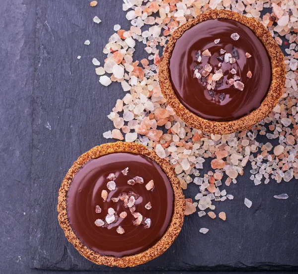 Homemade tarts of shortcrust pastry with dark chocolate and a pink sea salt — Stock Fotó