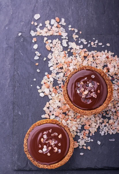 Homemade tarts of shortcrust pastry with dark chocolate and a pink sea salt — Stock Fotó