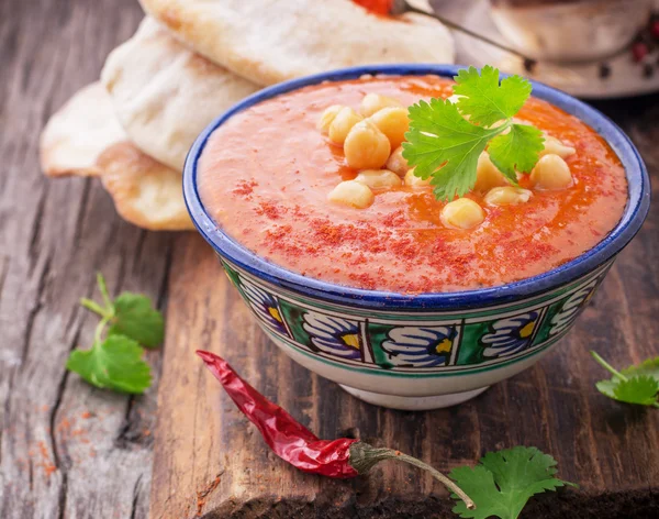 Cream soup puree of roasted tomatoes and peppers served with chickpeas cilantro