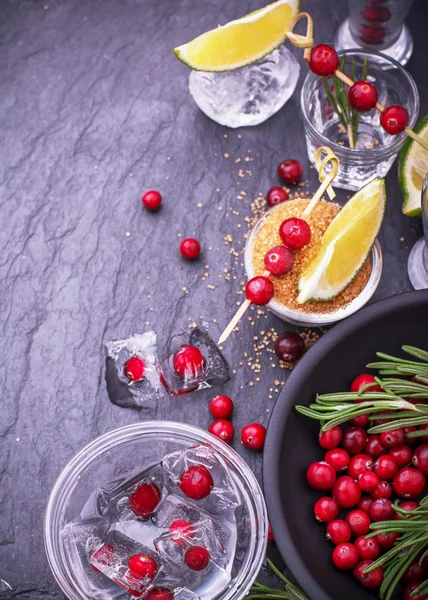 Ingredients for cranberry cocktail with lime and rosemary on a black stone — Stockfoto