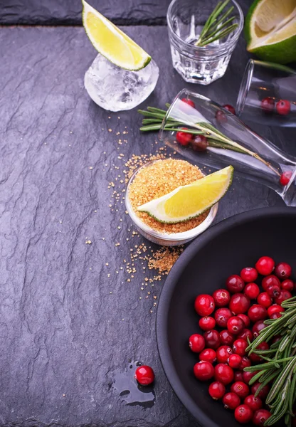 Ingredients for cranberry cocktail with lime and rosemary on a black stone — Stock fotografie