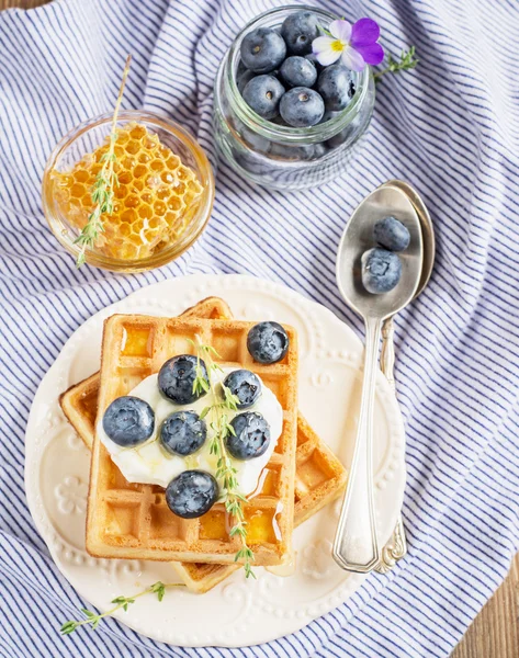 Belgian golden waffles for breakfast with fresh berries and flower honey on wooden background. The concept of home-cooked breakfast. — стокове фото