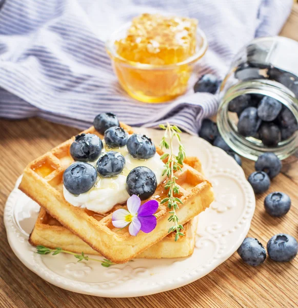 Belgian golden waffles for breakfast with fresh berries and flower honey on wooden background. The concept of home-cooked breakfast. — Stockfoto