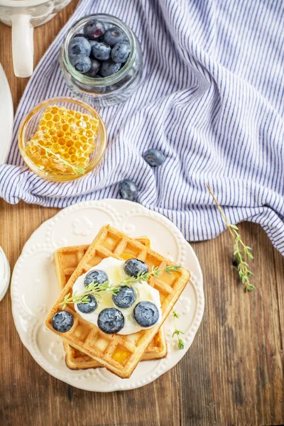 Belgian golden waffles for breakfast with fresh berries and flower honey on wooden background. The concept of home-cooked breakfast. — ストック写真