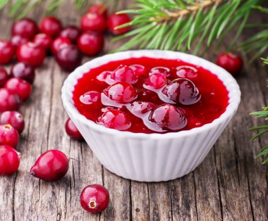 sauce of wild organic cranberries on a wooden table with berries 