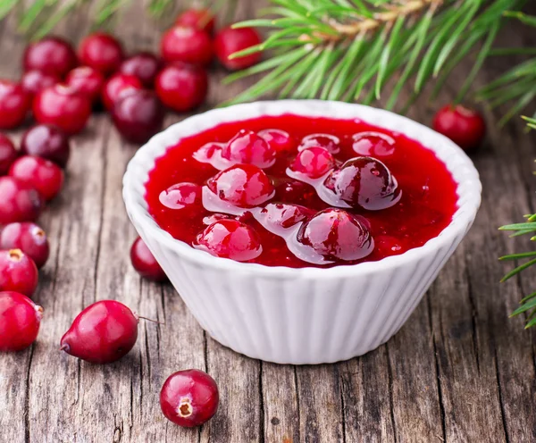 Sauce of wild organic cranberries on a wooden table with berries — Stock fotografie