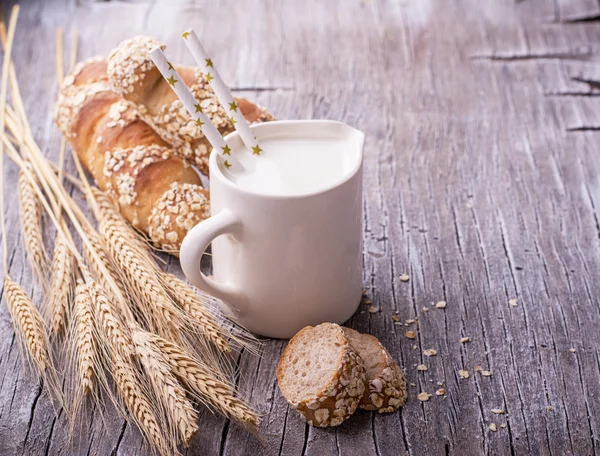 Jarro com leite para café da manhã e pão caseiro fresco baguetes orelhas — Fotografia de Stock