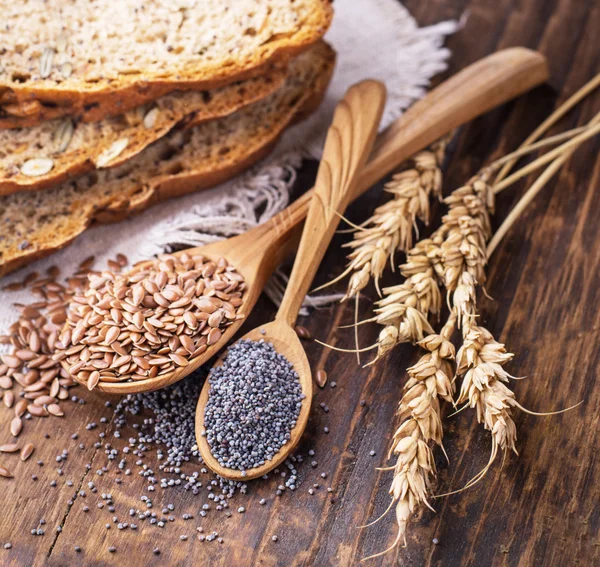 Segmenten van zelfgemaakte donkere geurige vers brood met maanzaad, vlas, zonnebloem en pompoen — Stockfoto