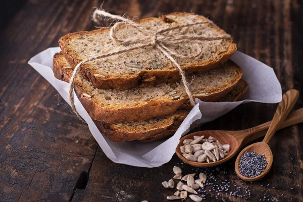 Rebanadas de pan fresco fragante oscuro casero con semillas de amapola, lino, girasol y calabaza — Foto de Stock