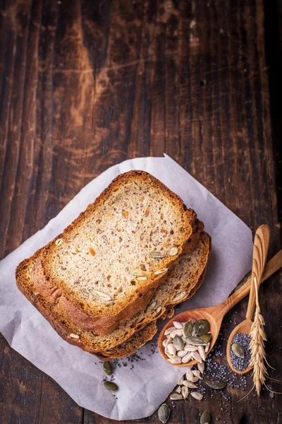 Fette di pane fresco scuro profumato fatto in casa con semi di papavero, lino, girasole e zucca — Foto Stock