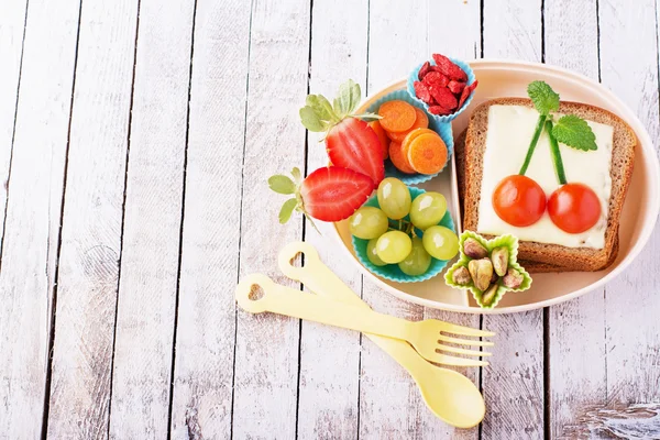 Lunch box for kids with fresh vegetables, fruits, nuts, berries