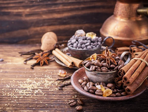 Grãos de café, gotas de chocolate, vagens de baunilha, paus de canela, estrelas de anis e açúcar mascavo — Fotografia de Stock