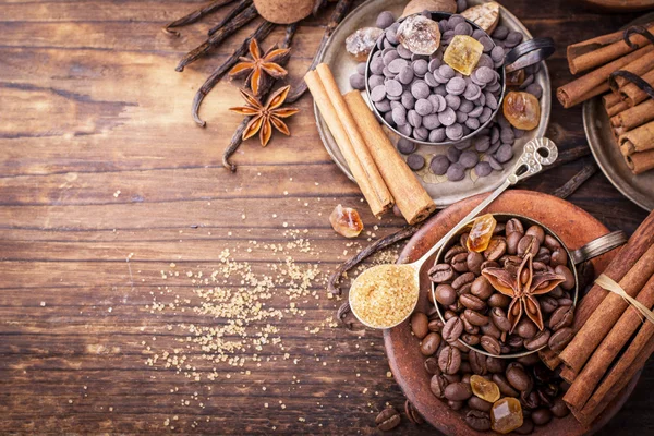 Chicchi di caffè, gocce di cioccolato, baccelli di vaniglia, bastoncini di cannella, stelle di anice e zucchero di canna — Foto Stock