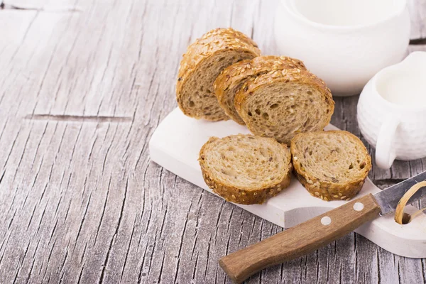Fette di pane di grano scuro su un tagliere — Foto Stock