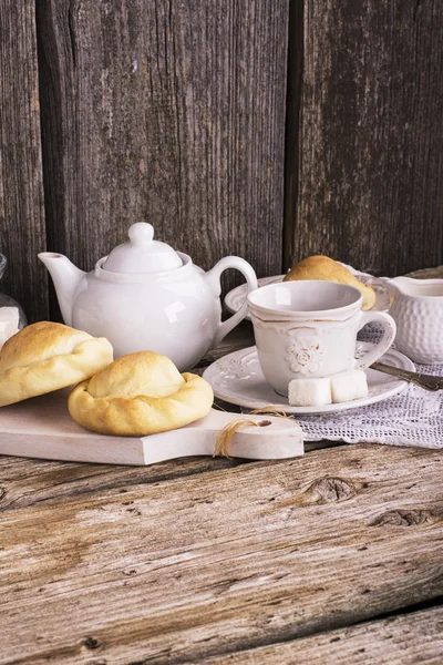 Kitchen simple still life of tea, cup, white sugar lump in a bank and fresh homemade cakes — Stock Fotó