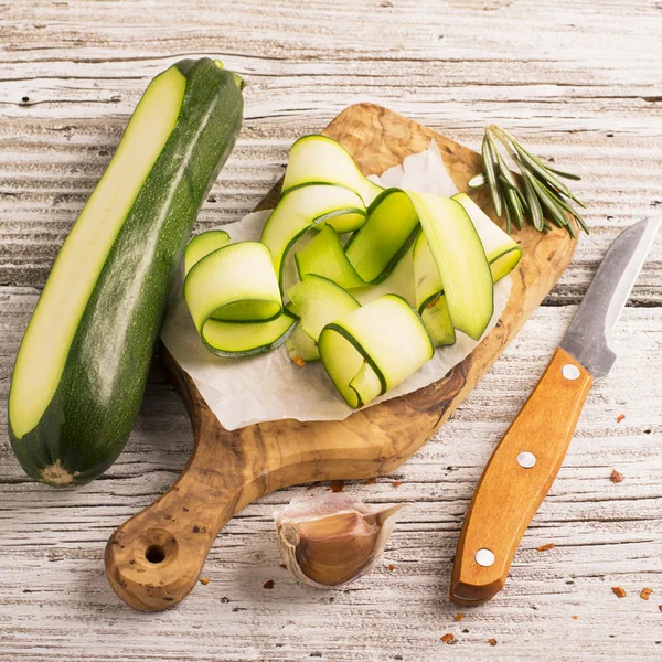 Dünne Scheiben Zucchini auf Olivenbrett — Stockfoto