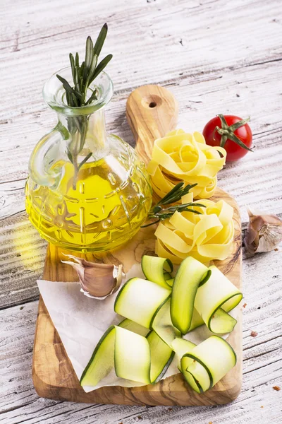 Ingrediënten voor het koken van pasta met groenten - spaghetti met courgette, tomaten, knoflook, rozemarijn, peper — Stockfoto