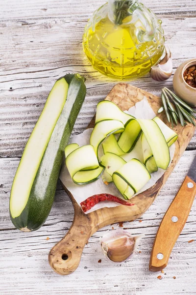 Dünne Scheiben Zucchini auf Olivenbrett — Stockfoto