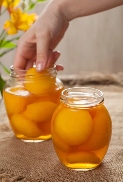 Canned natural vegetarian peaches in glass jars with compote — Stock Photo, Image