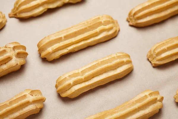 Traditional French eclairs or profiterole dessert food on baking sheet — Stock Photo, Image