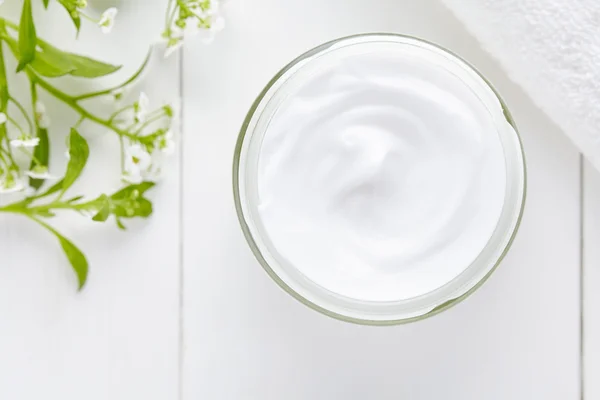 Creme cosmético com flores de ervas no fundo branco Imagem De Stock