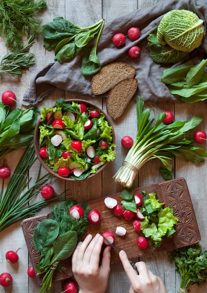 Preparando a salada sã vegetal de primavera com rabanete, pepino, couve sabóia — Fotografia de Stock