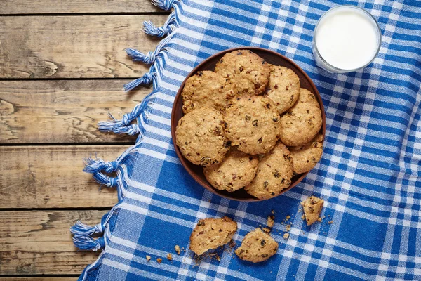 Traditional baked cereal oatmeal cookies with raisins and glass of milk — Stock Photo, Image