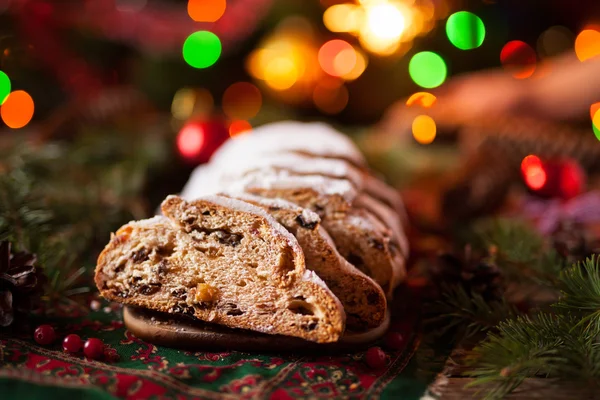 Рождественский торт и праздничные украшения. Традиционный немецкий Stollen с ягодами, орехами, марципаном . — стоковое фото