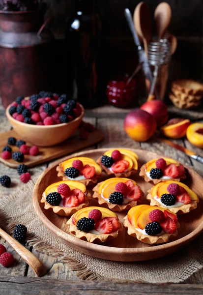 Fresh berry tartlet or cake with vanilla custard, raspberry, peach and blackberry. Rustic style. Close up. — Stock Photo, Image