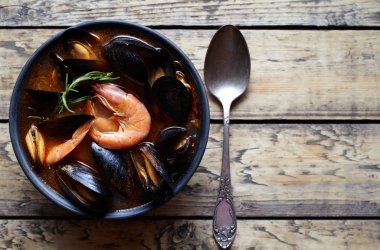 Deniz ürünleri, karides, midye domates, ıstakoz ile balık çorbası. Rustik tarzı arka plan. Düz yatıyordu.