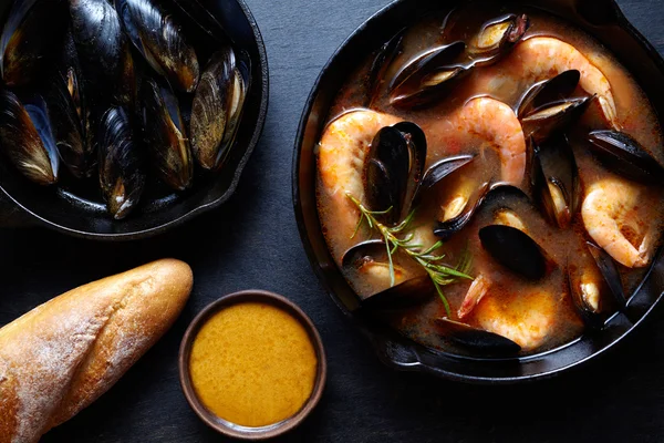 Sopa de mariscos Bouillabaisse con pescado, gambas, mejillones tomate, langosta. Fondo rústico de estilo oscuro. Puesta plana . — Foto de Stock