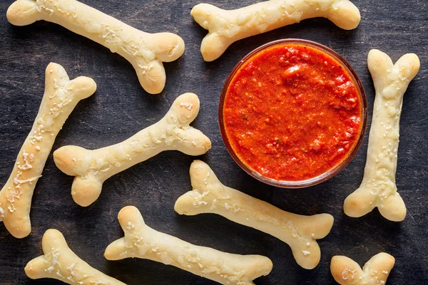 Creative Halloween dough bones cookies snack with fake blood tomato sauce and mozzarella — Stock Photo, Image