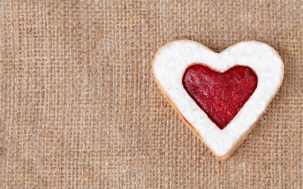 Herzförmiger Keks zum Valentinstag auf textilem Hintergrund — Stockfoto