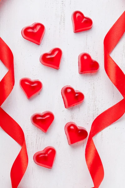 Heart shaped red jelly candies and ribbons on vintage background — Stock Photo, Image