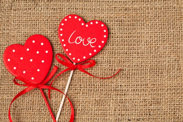 Червоні серця дня Святого Валентина на старовинному текстильному фоні — стокове фото
