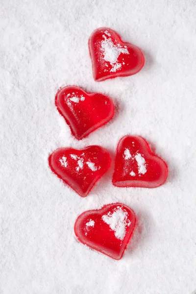 Red heart shaped jelly on powdered sugar-like snow — Stock Photo, Image