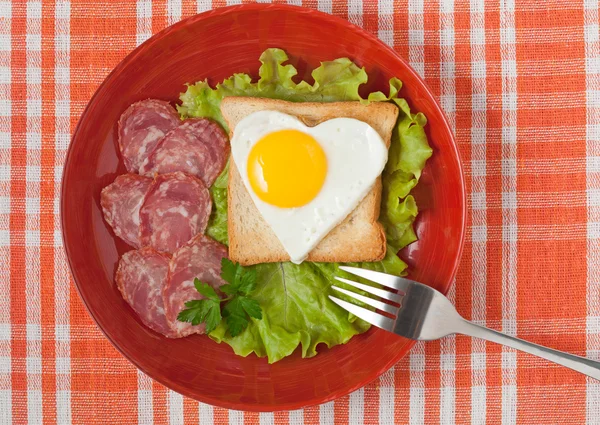 Uovo fritto a forma di cuore su pane tostato con insalata e salsiccia per Valen — Foto Stock