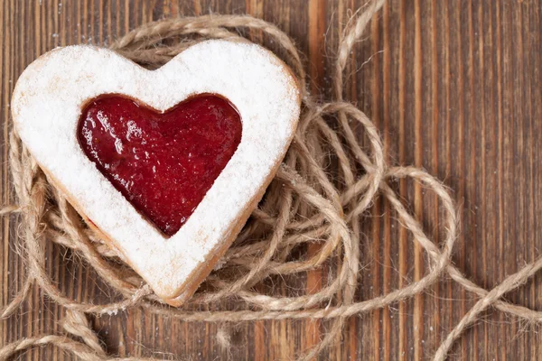 Heart shaped cookie with jam on vintage wooden background — Stock Photo, Image