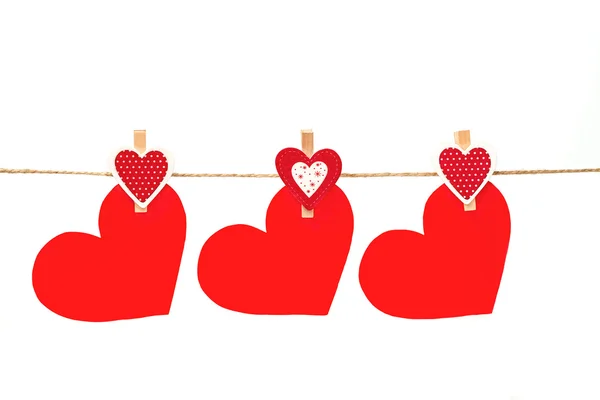 Three red hearts hanging on twine on isolated background — Stock Photo, Image