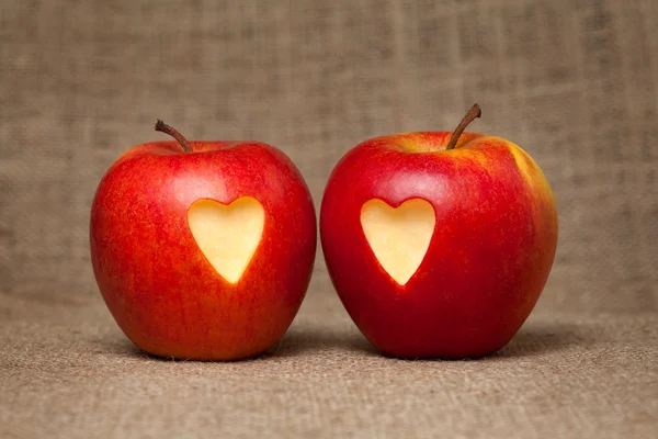 Dvě jablka s srdce na vinobraní textilní pozadí — Stock fotografie