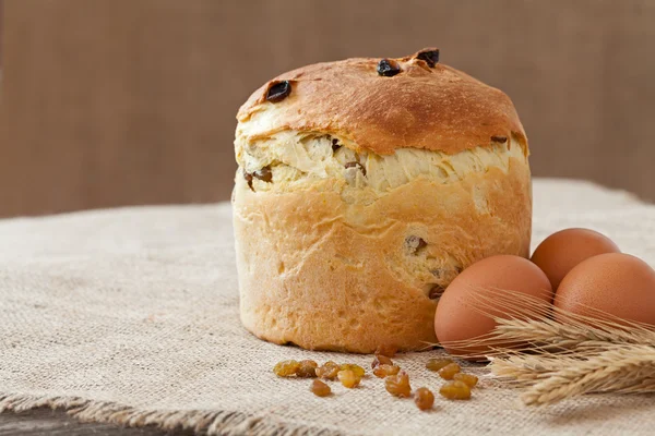 Ízletes támogatott hagyományos orosz kulich Húsvét sütemény a mazsolát és a vintage textil tojás — Stock Fotó