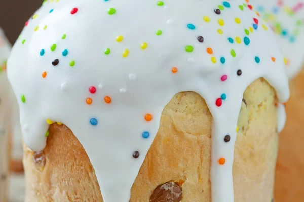 Pan dulce casero tradicional panettone pastel de Pascua también llamado kulich glaseado con glaseado y pasas en textil vintage. Primer plano de tiro — Foto de Stock