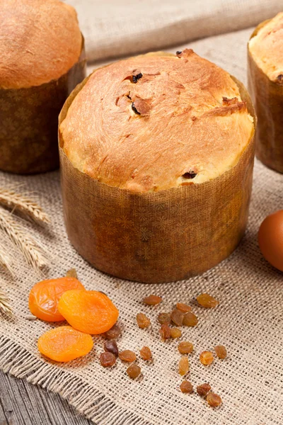 Traditional italian panettone cake sweet desset bread with raisins and dried apricots on vintage textile — Stock Photo, Image
