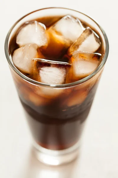 Cola kall söt läsk dryck med isbitar och bubblor i genomskinligt glas — Stockfoto