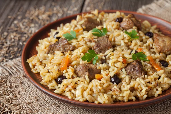 Tazón de barro vintage con comida picante tradicional llamada pilaf, sobre fondo de madera — Foto de Stock