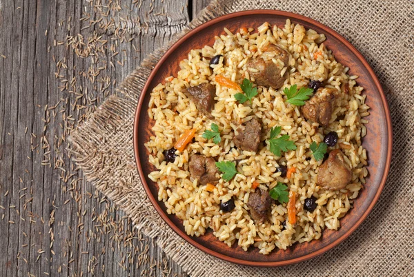 Arroz árabe nacional chamado pilaf cozido com carne frita, cebola, cenoura e alho Fotografia De Stock