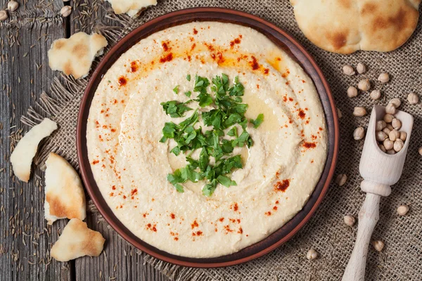 Hummus savoureux aliment traditionnel à la pâte de tahini, huile d'olive, paprika et persil — Photo