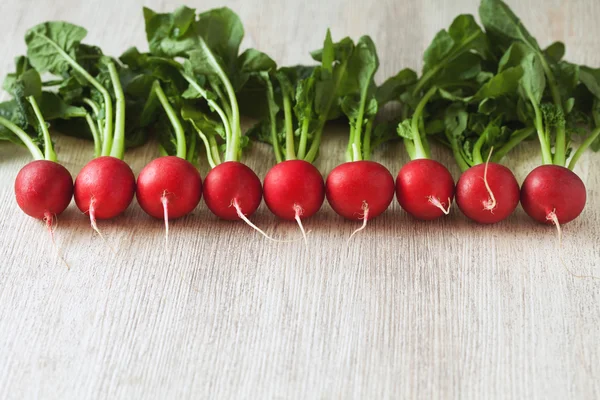 Vegetariska hälsosamma äta rädisor på rustika trä bakgrund — Stockfoto