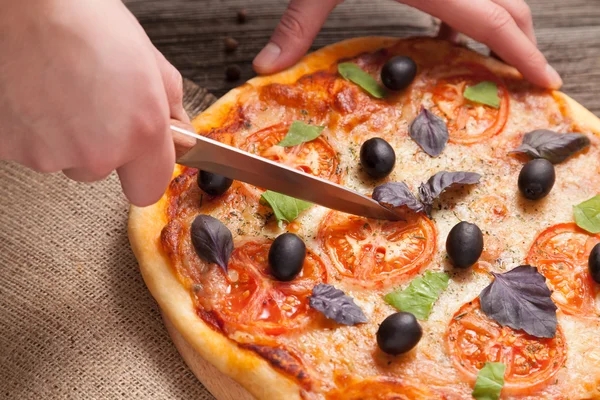 Corte com faca italiana pizza margherita com tomate, azeitona — Fotografia de Stock